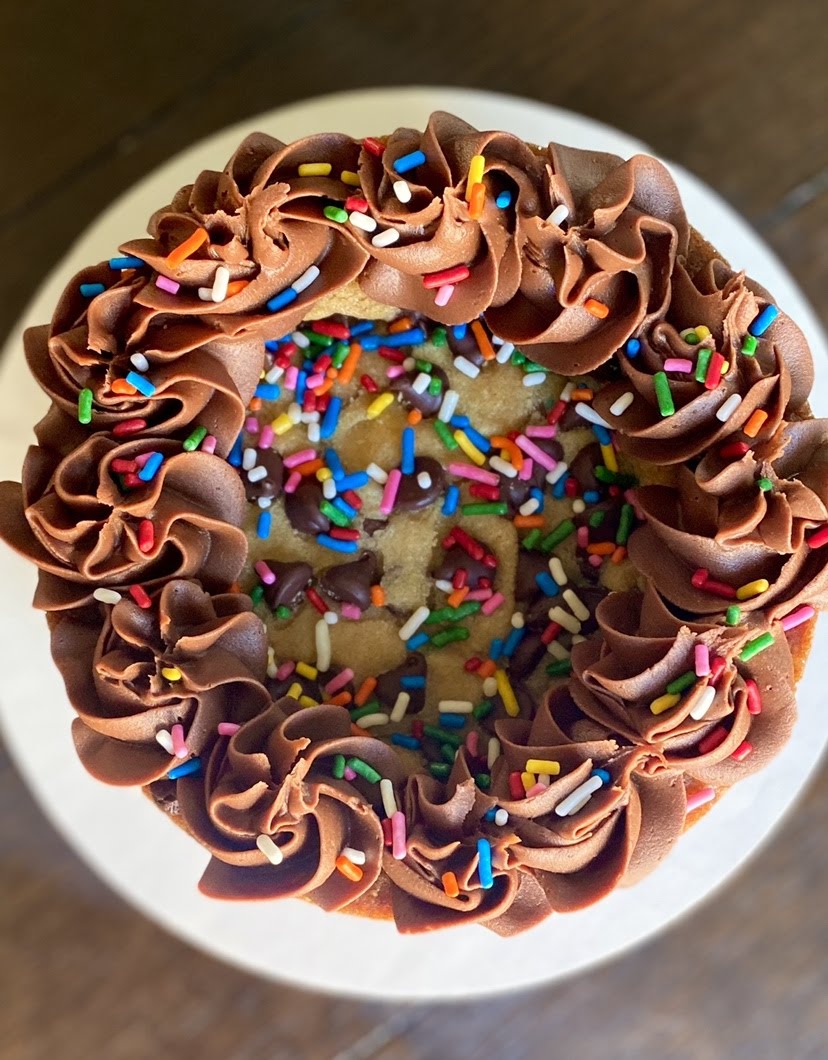 The top of a Layered Chocolate Chip Cookie Cake with chocolate buttercream frosting piped into rosettes. 