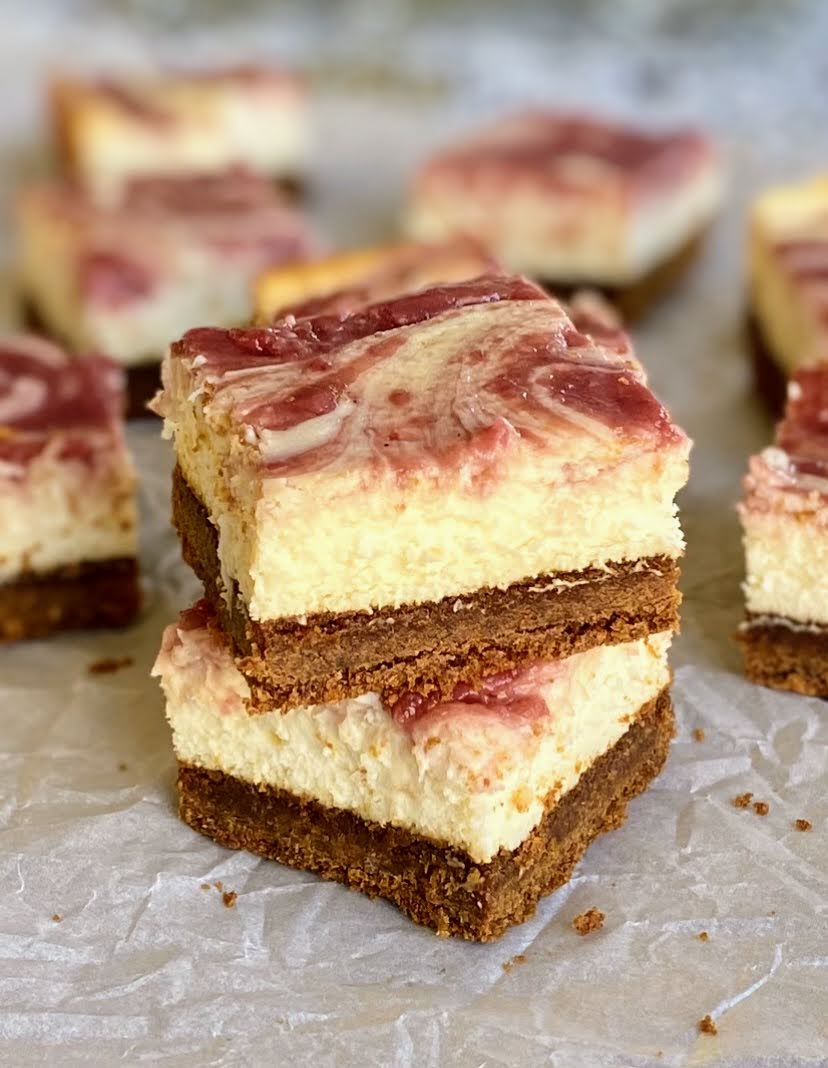 a stack of gingerbread cranberry cheesecake bars