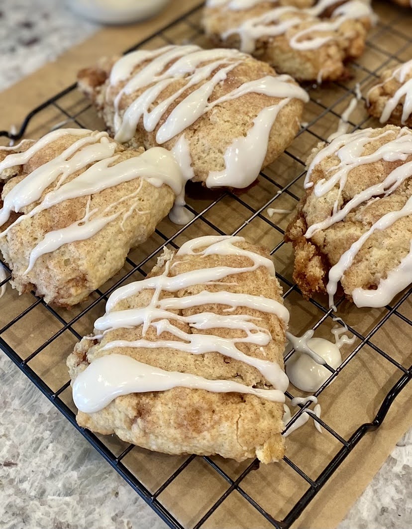 cinnamon swirl scones cooling on a baking rack topped with icing