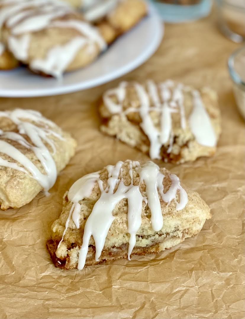 cinnamon scones on parchment topped with icing