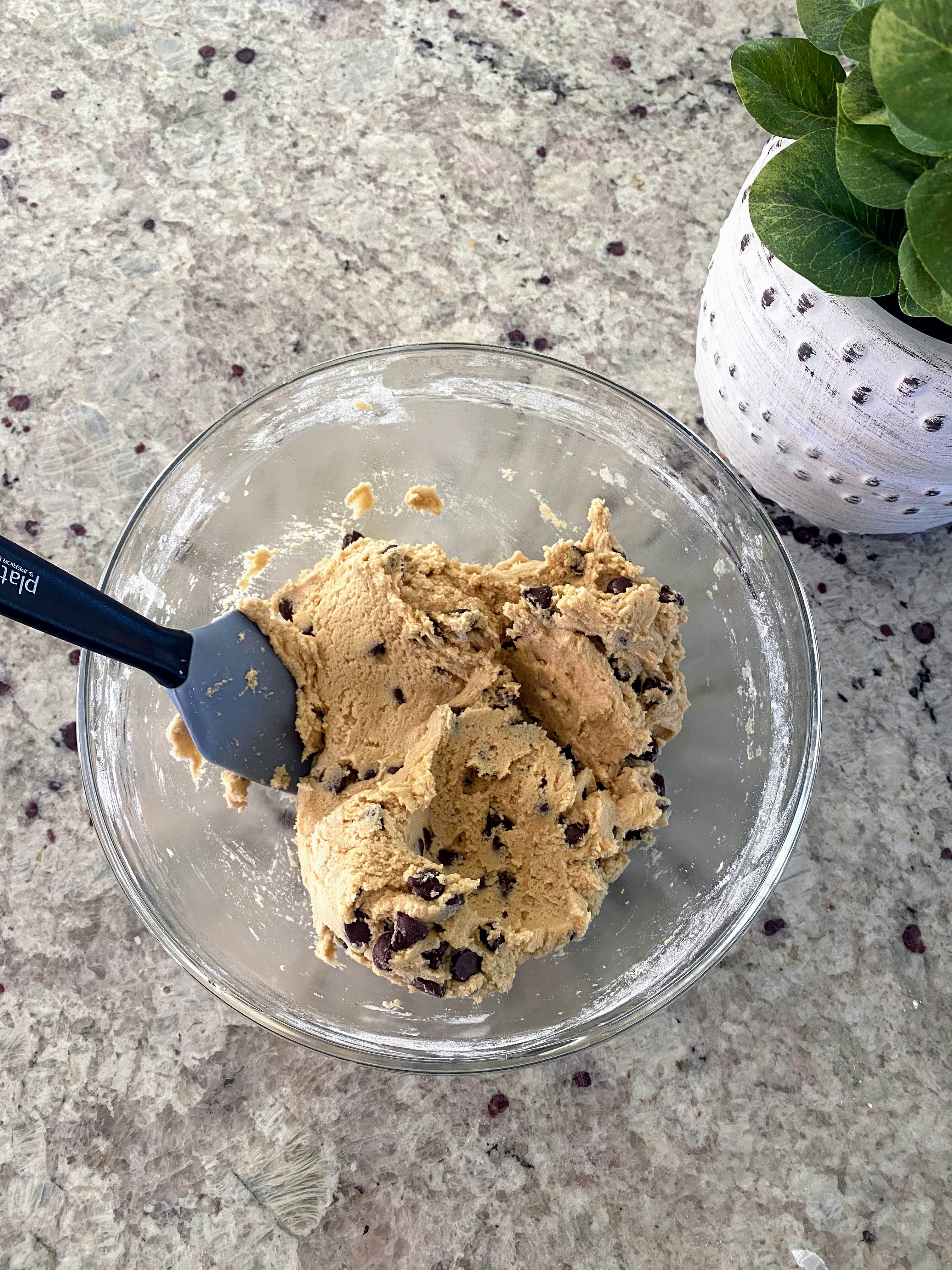 A glass mixing bowl with edible cookie dough. 