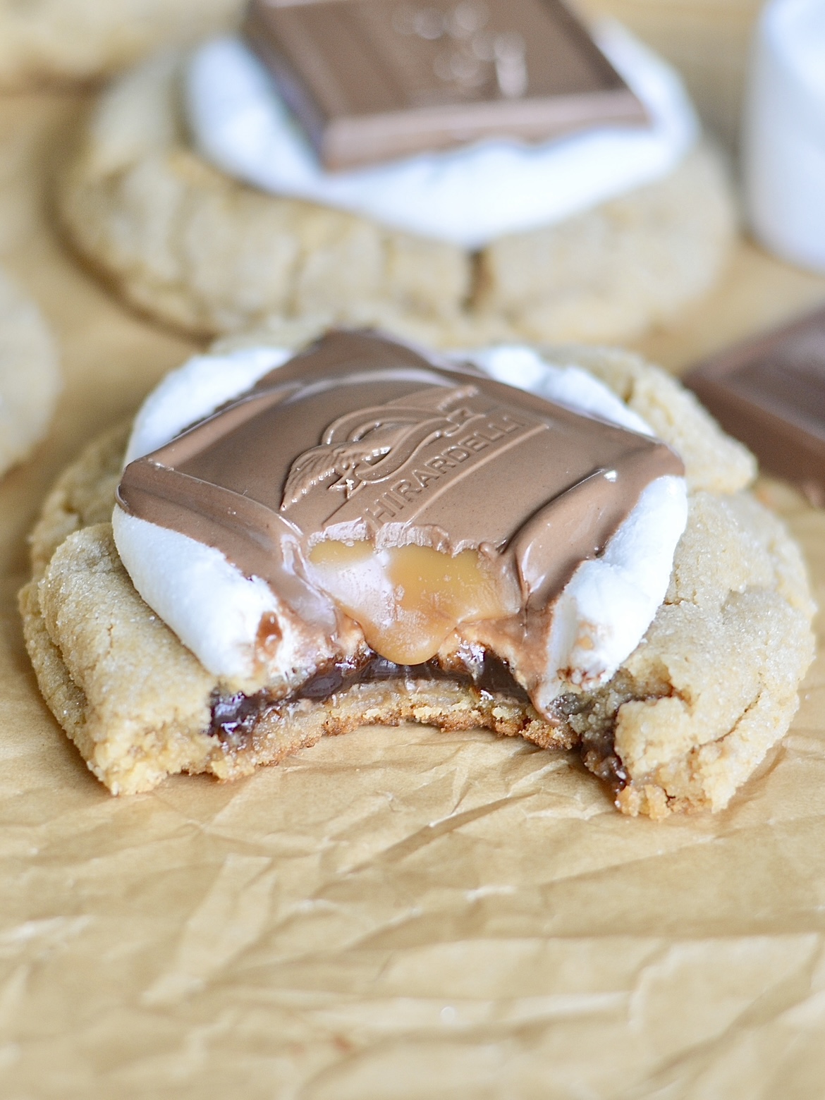a chocolate-filled peanut butter cookie topped with a marshmallow and Ghirardelli chocolate square with a bite taken out of it