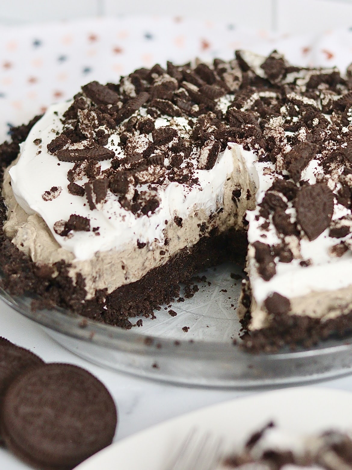 An oreo truffle cream pie with a slice removed from it.