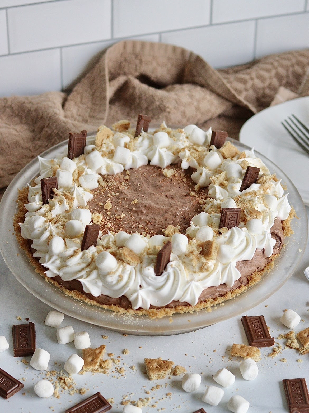 A full chocolate cream s'mores pie, decorated with Hershey's pieces, graham crackers and marshmallows.