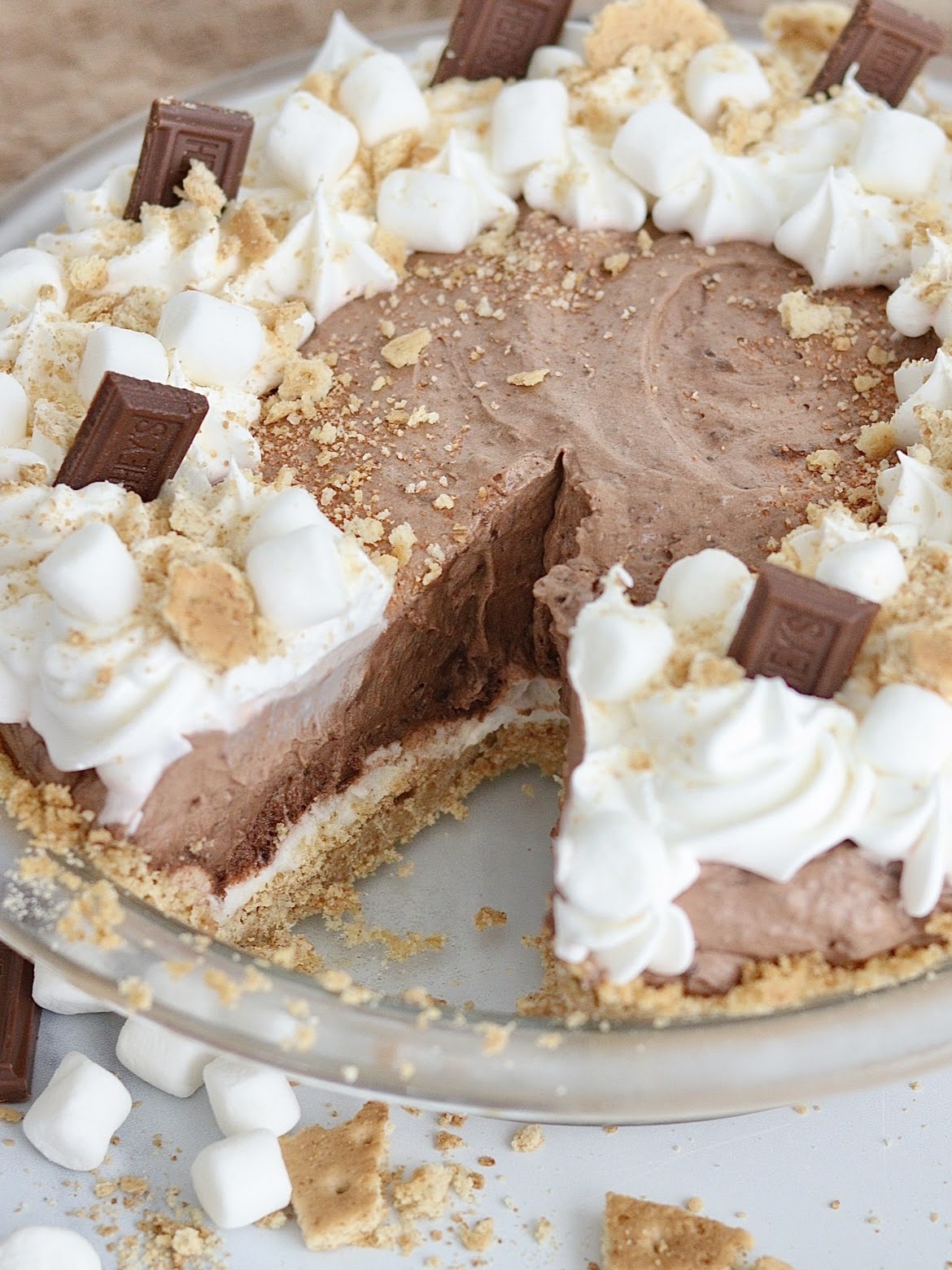 S'mores cream pie with a slice taken out of it, showing the marshmallow layer and graham cracker crust.