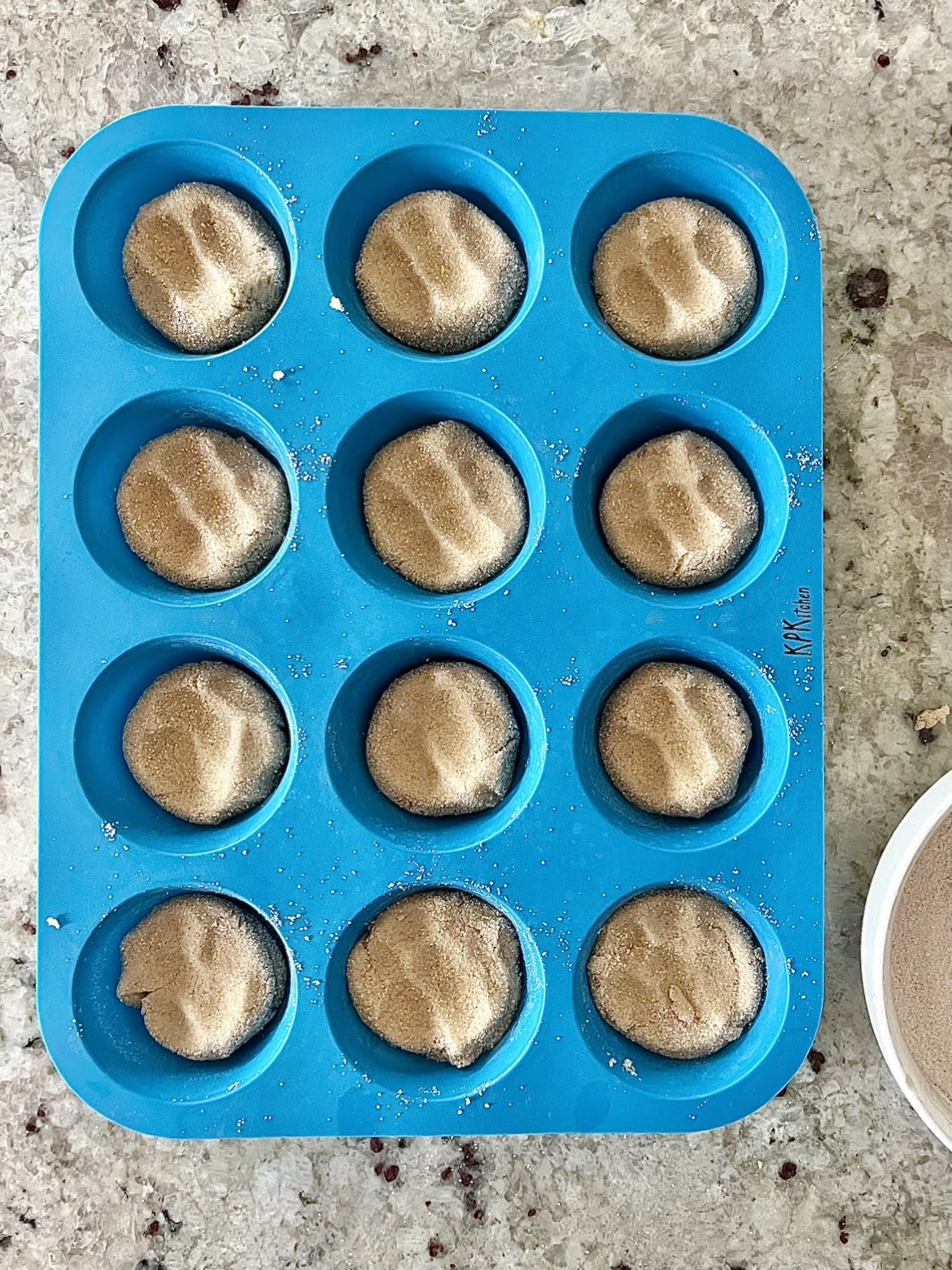 A process photo of the cookie dough pressed into the muffin tins prior to baking