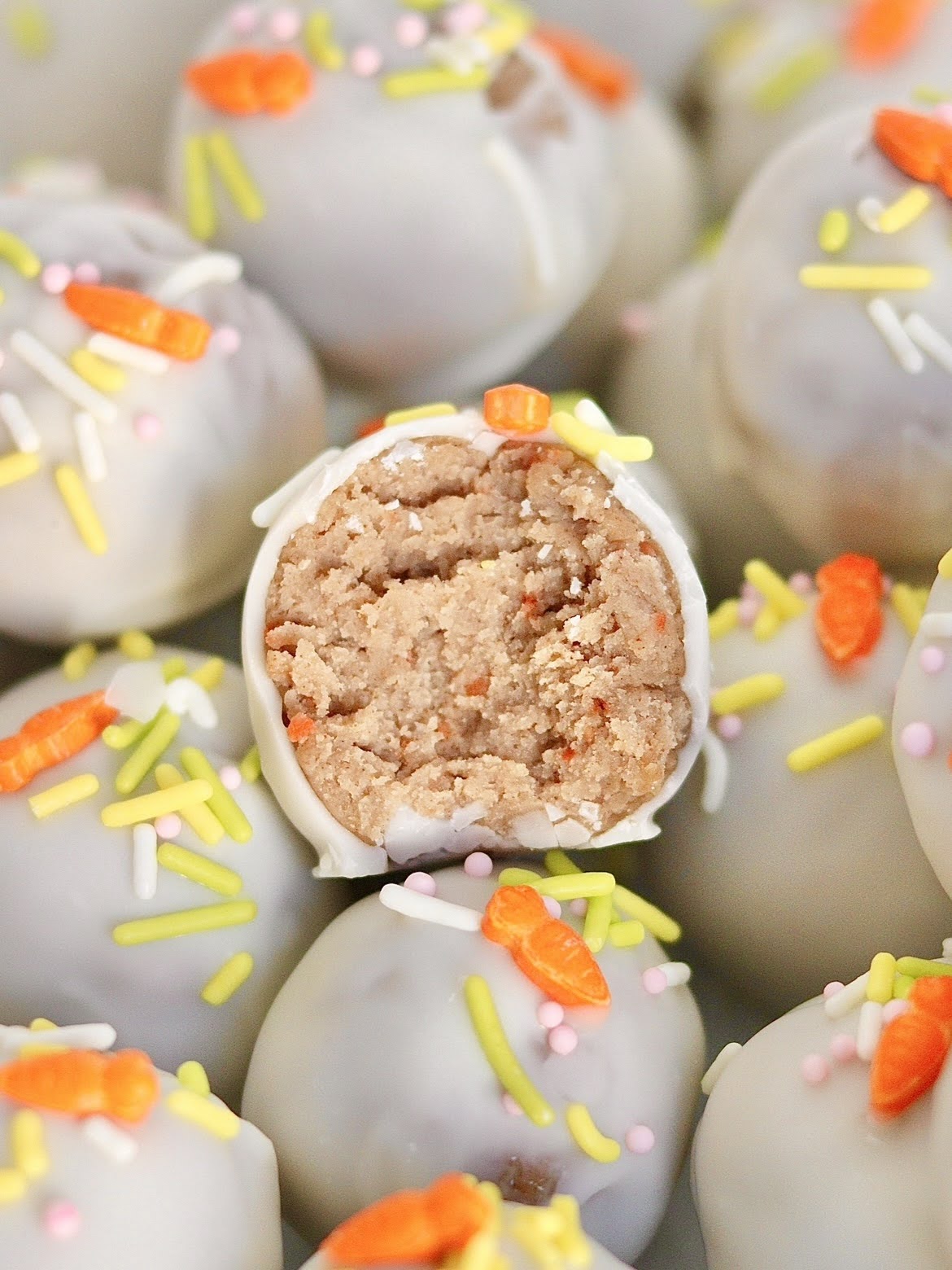 A carrot cake truffle with a bite taken out of it.