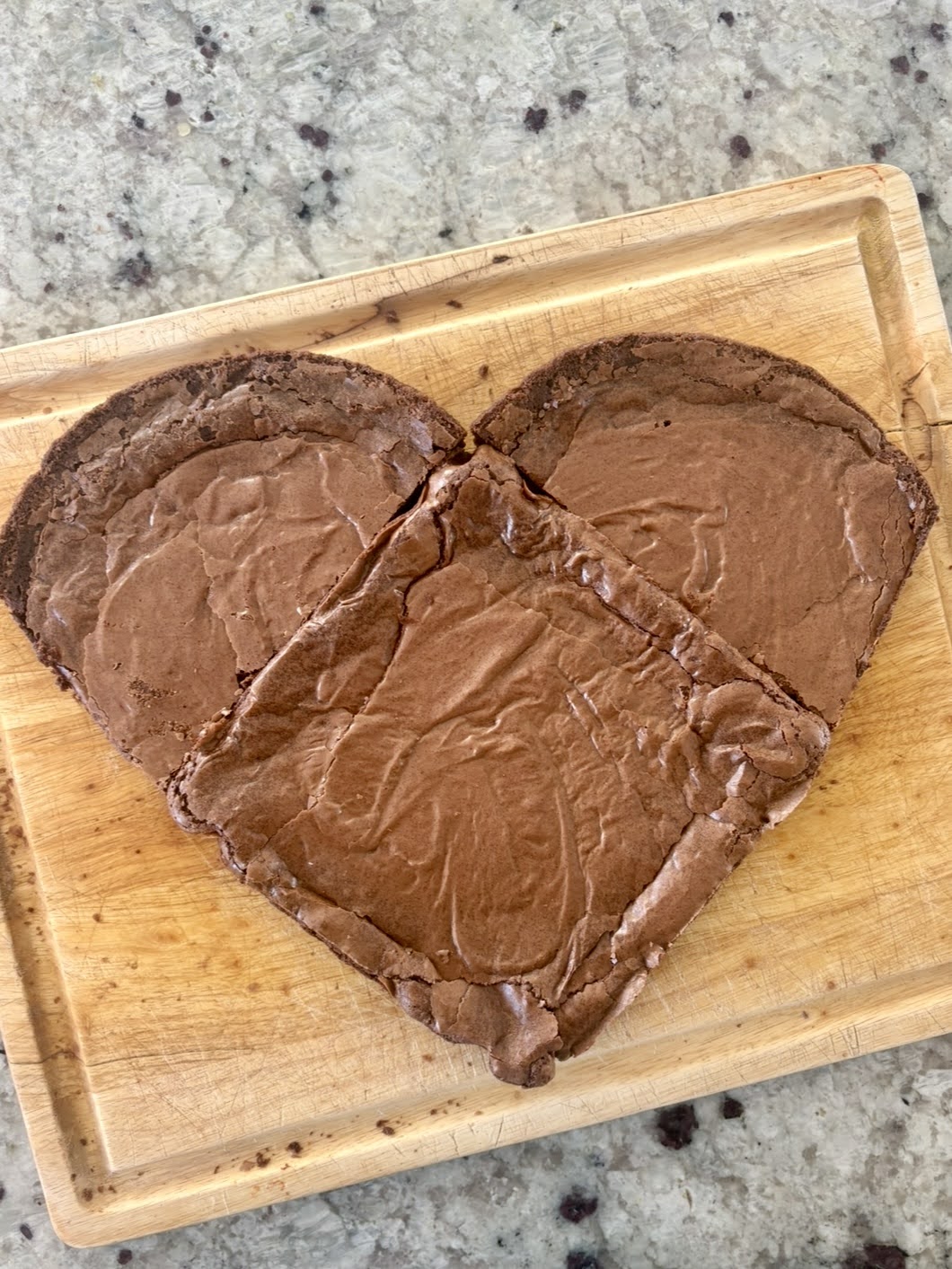 second process photo for the heart shaped brownie, showing how to trim the sides of the halved round brownie to form the two shapes into a heart